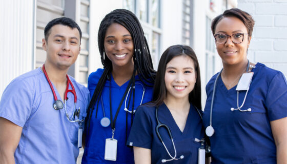 Diverse group of four nursing students standing together outdoors
